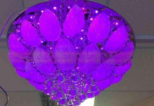 Фиолетовой подсветкой люстра хрусталь